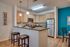 Modern kitchen with wooden cabinets, stainless steel appliances, and chic pendant lighting.