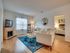 Bright living room with a modern fireplace, stylish seating area, and connecting bedroom view.