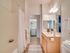 Modern bathroom with elegant vanity, mirror, and access to laundry area.