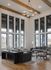 Spacious modern living room with high ceilings, large windows, and stylish furniture.