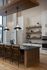 Modern kitchen with wooden elements, pendant lighting, and open shelving.