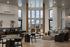 Modern lounge area featuring large windows, stylish furniture, and wooden accents.