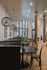 Elegant dining space with modern lighting, stylish wooden columns, and large windows.