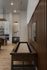 Modern living area featuring a shuffleboard table, wooden paneling, and a stylish kitchen in the background.