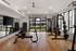 Well-equipped apartment gym with modern fitness equipment and large windows.