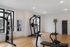 Bright and spacious home gym with modern exercise equipment and wood flooring.