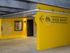 Colorful yellow bike shop entrance with bold signage and geometric wall art.