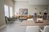 Stylish living room with modern furniture, featuring artwork of dogs in suits and a cozy workspace.