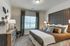 Cozy and stylish bedroom with modern decor, featuring a plush bed and large window letting in natural light.