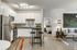 Modern kitchen and living area with stylish decor and cozy bedroom in the background.