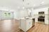 Modern, spacious kitchen with sleek white cabinets, stainless steel appliances, and hardwood flooring.