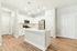 Bright, stylish kitchen with sleek white cabinetry, island, and stainless steel appliances.