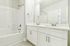 Bright and modern bathroom with dual sinks and a spacious bathtub.