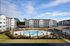 Aerial view of a modern apartment complex with a pristine pool area surrounded by lush landscaping.