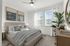 Bright and modern bedroom with cozy bed, stylish decor, and large windows allowing natural light.