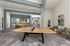 Stylish covered outdoor lounge area featuring a ping pong table, seating, and vibrant decor.
