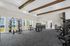 Bright and airy gym with modern equipment, large windows, and exposed wooden beams.