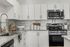 Modern kitchen with sleek stainless steel appliances, granite countertops, and white cabinetry.
