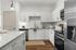 Contemporary kitchen with white cabinets, granite countertops, and stainless steel appliances.