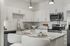 Contemporary kitchen with gray granite countertops, white cabinets, and stainless steel appliances.