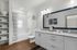 Sleek and contemporary bathroom with granite countertops, a large mirror, and a bathtub, accented by stylish decor.