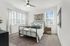 Bright and stylish bedroom with a cozy bed, modern decor, and large windows letting in natural light.