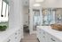 Chic kitchen with white cabinets, an elegant island, and a view into the dining area.