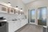 Elegant kitchen with white cabinets, marble backsplash, and sleek lighting.