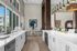 Chic and spacious kitchen with white countertops, modern lighting, and a scenic window view.