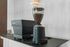 Sleek modern coffee grinder and machine on a stylish kitchen countertop.
