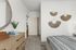 Inviting bedroom with modern decor, featuring a wooden dresser and abstract wall art.