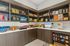 Well-organized pantry area with a variety of snacks, cereals, and essentials on wooden shelves and a sleek countertop.