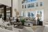 Elegant interior living room with plush sofas, large windows, and a view of the swimming pool.