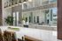 Chic modern kitchen with large white countertop, stylish pendant lights, and greenery accents.