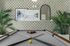 Elegant game room with a billiard table, stylish geometric wallpaper, and decorative wall art.
