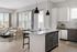 Bright and modern open-concept kitchen and living room with sleek decor and large windows.