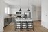 Sleek modern kitchen with white cabinets, stainless steel appliances, and a central island with bar stools.