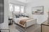 Bright and modern bedroom featuring a stylish bed, cozy textiles, and contemporary artwork.