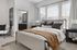 Luxurious bedroom with plush pillows, large windows, and stylish decor.