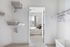 Modern walk-in closet with ample shelving, hangers, and a view into a cozy, well-lit bedroom.