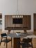Modern entertainment area with a sleek pool table beneath elegant lighting, accented by a stylish wooden partition.
