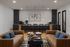 Stylish living area with tan sofas, chic decor, and a functional kitchen island in a contemporary setting.