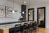 Modern dining room with elegant lighting, bike-themed artwork, and sleek black cabinetry.