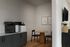 Inviting home office area with multifunction printers, a round wooden table, and modern decor.