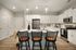 Inviting modern kitchen with white cabinets, stainless steel appliances, and a stylish island with seating.