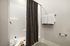 Inviting bathroom with a stylish shower, textured curtain, and fresh white towels.