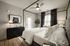 Chic bedroom featuring a stylish canopy bed, elegant decor, and a modern ceiling fan.