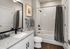Elegant bathroom featuring a sleek granite countertop, modern fixtures, and a stylish shower with white subway tiles.