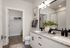 Luxurious modern bathroom with granite countertops, elegant lighting, and a spacious walk-in closet, perfect for comfortable living.