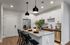 Modern kitchen with sleek granite countertops, stylish pendant lighting, and elegant dining setup.